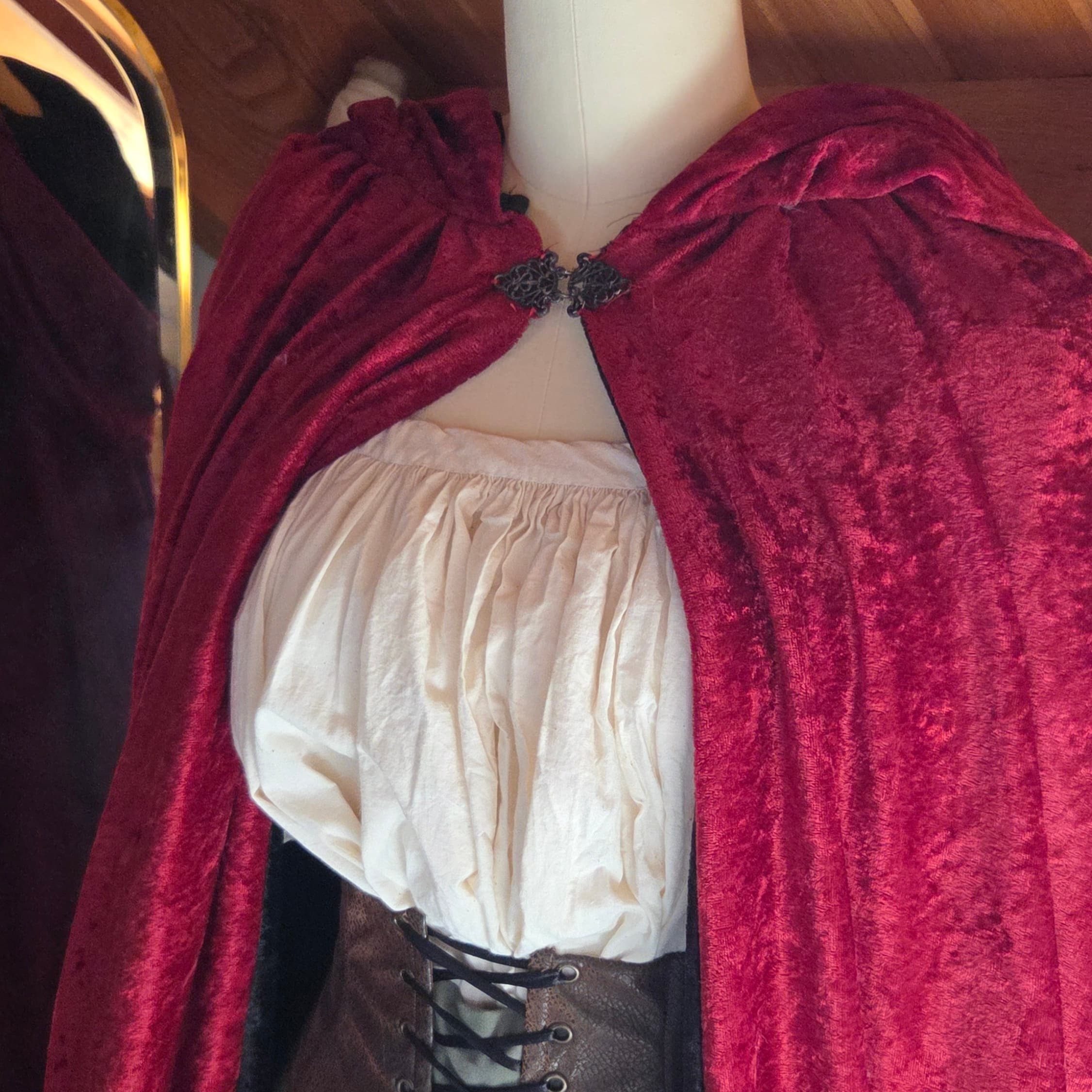 red velvet cloak with tarnished silver clasp closure